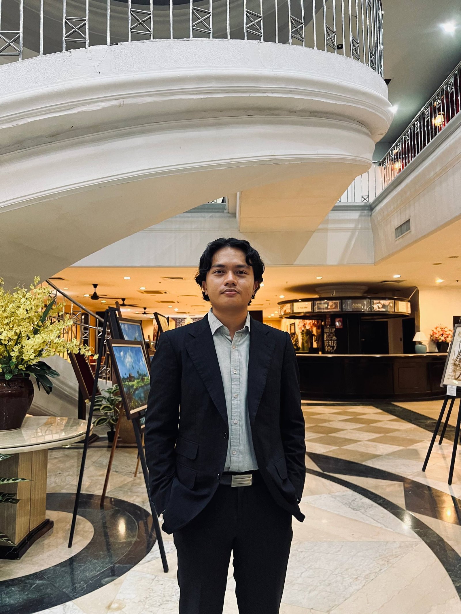 Portrait of Ahmad Ziyad standing indoors in a dark blazer
